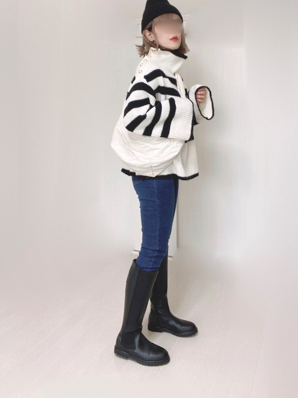 ブラック系のブーツ、ホワイト系のニット/セーター、ホワイト系のショルダーバッグを着用したレディースの秋コーディネートの3枚目の写真