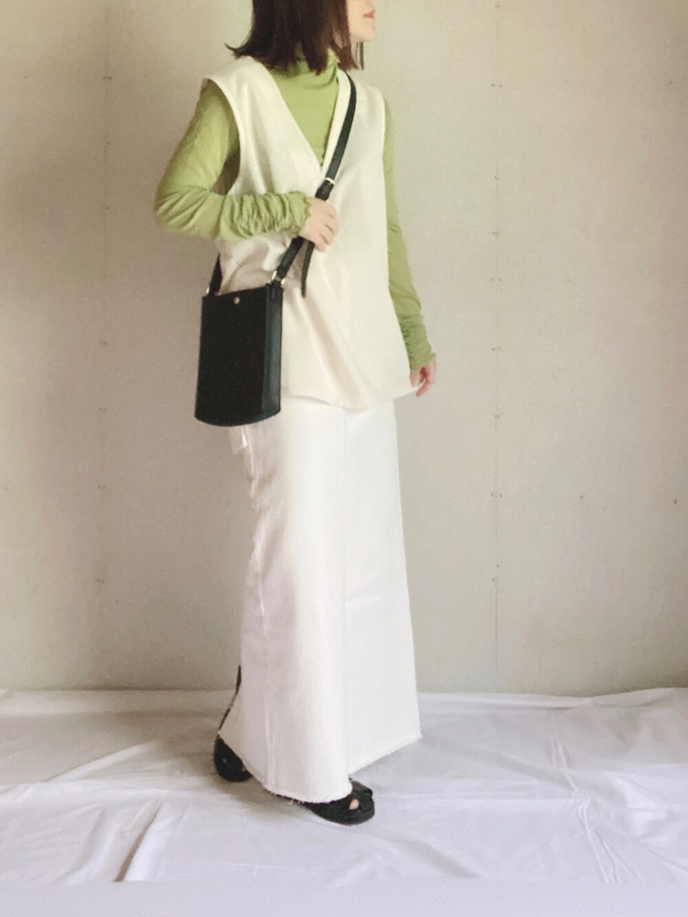 ベージュ系のデニムスカート、グリーン系のTシャツ/カットソー、ブラック系のショルダーバッグを着用したレディースの夏コーディネートの5枚目の写真