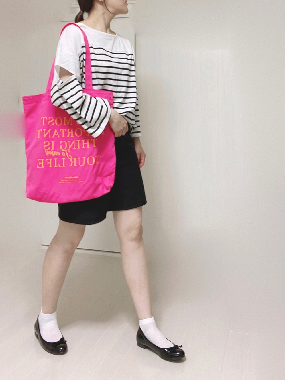ブラック系のその他パンツ、ブラック系のTシャツ/カットソー、ピンク系のトートバッグを着用したレディースの夏コーディネートの3枚目の写真