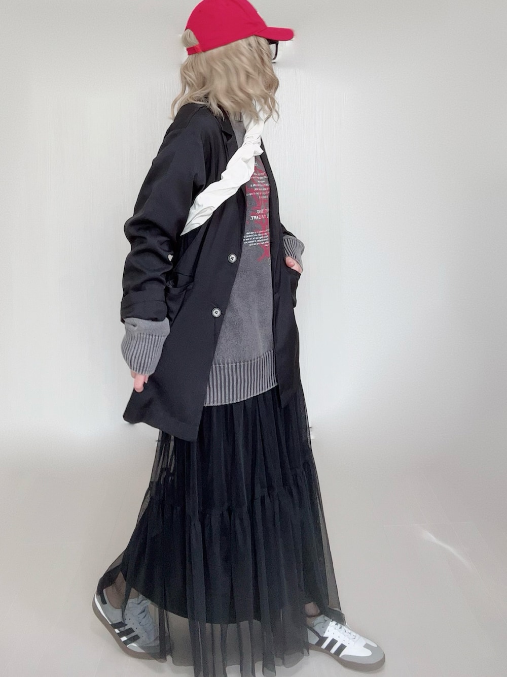 ブラック系のニット/セーター、ブラック系のテーラードジャケット、ブラック系のスカートを着用したレディースの冬コーディネートの2枚目の写真