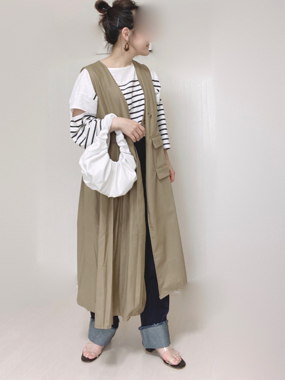 ベージュ系のワンピース、ブラック系のTシャツ/カットソー、ブルー系のデニムパンツを着用したレディースの夏コーディネートの5枚目の写真