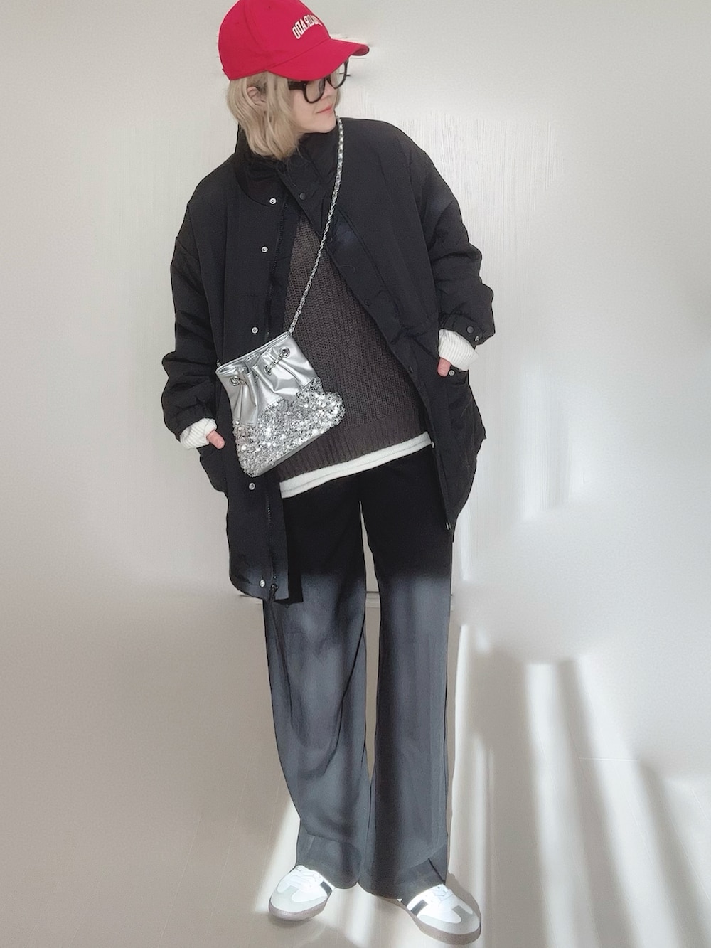 ブラック系のブルゾン、グレー系のニット/セーター、シルバー系のショルダーバッグを着用したレディースの冬コーディネートの3枚目の写真