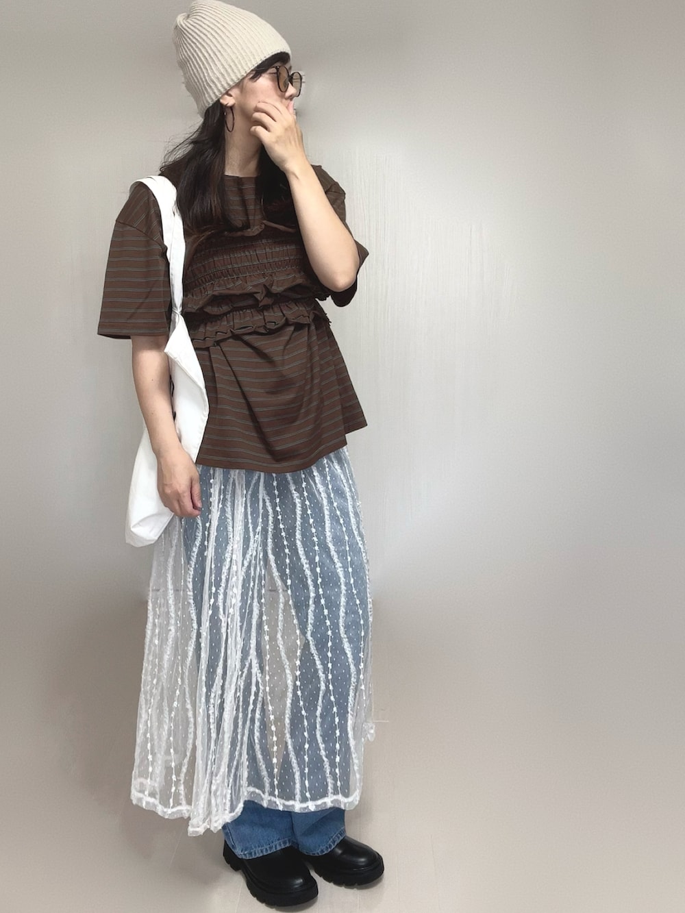 ブラウン系のTシャツ/カットソー、ブルー系のデニムパンツ、ホワイト系のスカートを着用したレディースの夏コーディネートの4枚目の写真