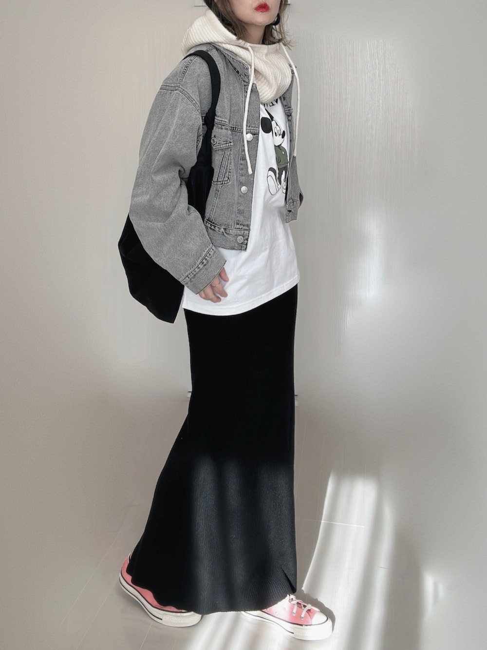 ブラック系のデニムジャケット、ホワイト系のTシャツ/カットソー、ブラック系のスカートを着用したレディースの冬コーディネートの2枚目の写真