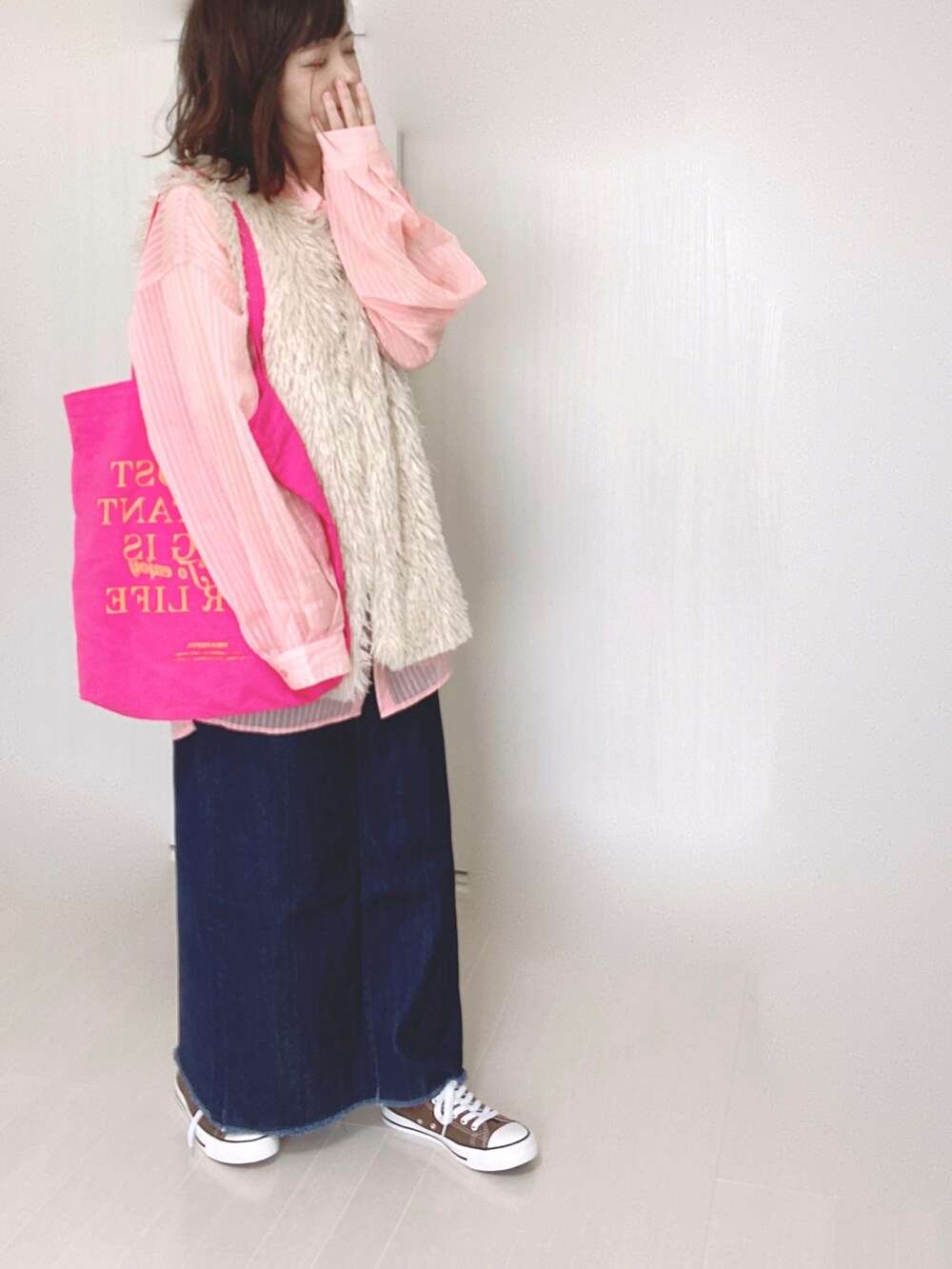 ホワイト系のベスト、ピンク系のシャツ/ブラウス、ブルー系のデニムスカートを着用したレディースの秋コーディネートの5枚目の写真