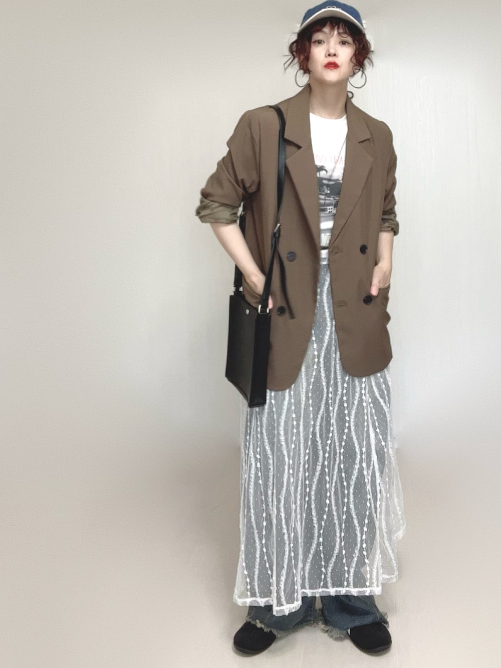 ブラウン系のテーラードジャケット、ブルー系のデニムパンツ、ホワイト系のスカートを着用したレディースの夏コーディネートの2枚目の写真