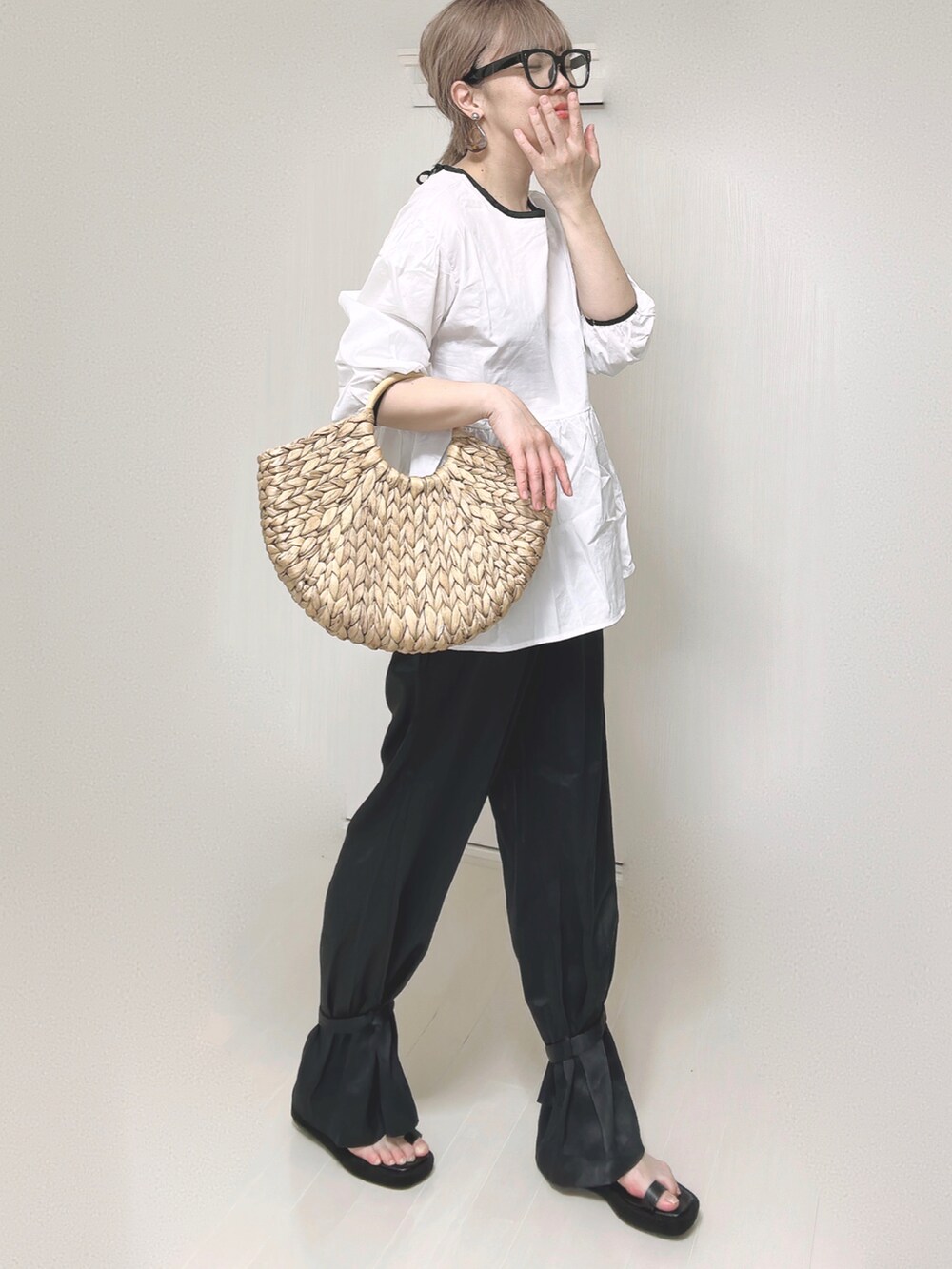 ブラック系のその他パンツ、ホワイト系のシャツ/ブラウス、ベージュ系のかごバッグを着用したレディースの夏コーディネートの3枚目の写真