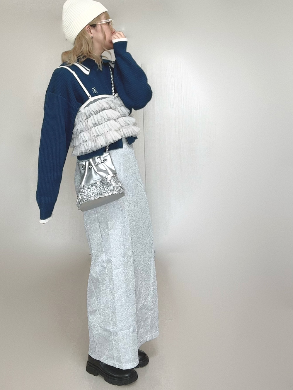 ブルー系のニット/セーター、ブラック系のブーツ、シルバー系のショルダーバッグを着用したレディースの秋コーディネートの4枚目の写真