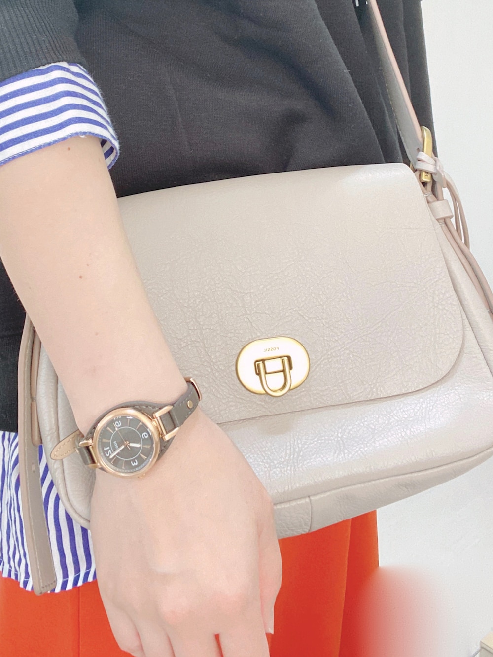 グレー系のメッセンジャーバッグ、ブラック系のスウェット、ブルー系のシャツ/ブラウスを着用したレディースの秋コーディネートの2枚目の写真