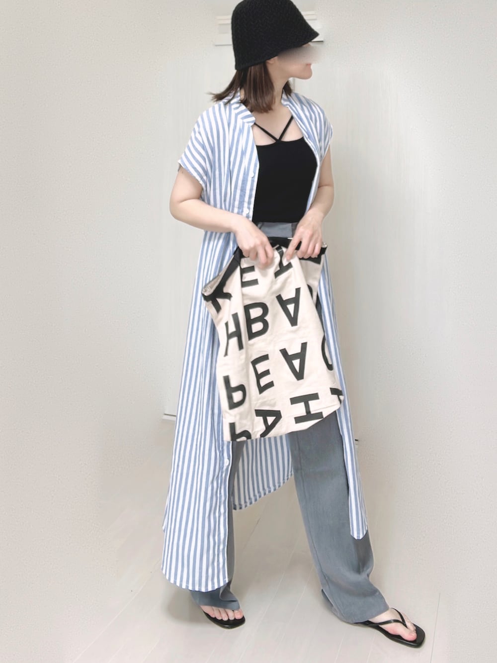 ブラック系のキャミソール、ブルー系のシャツワンピース、ホワイト系のトートバッグを着用したレディースの夏コーディネートの4枚目の写真