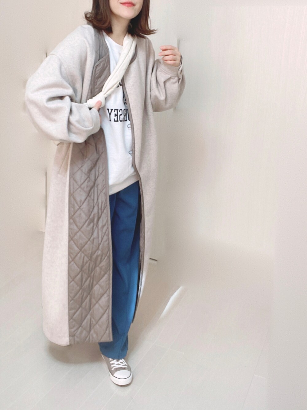 ベージュ系のノーカラーコート、ホワイト系のスウェット、ブルー系のその他パンツを着用したレディースの冬コーディネートの5枚目の写真
