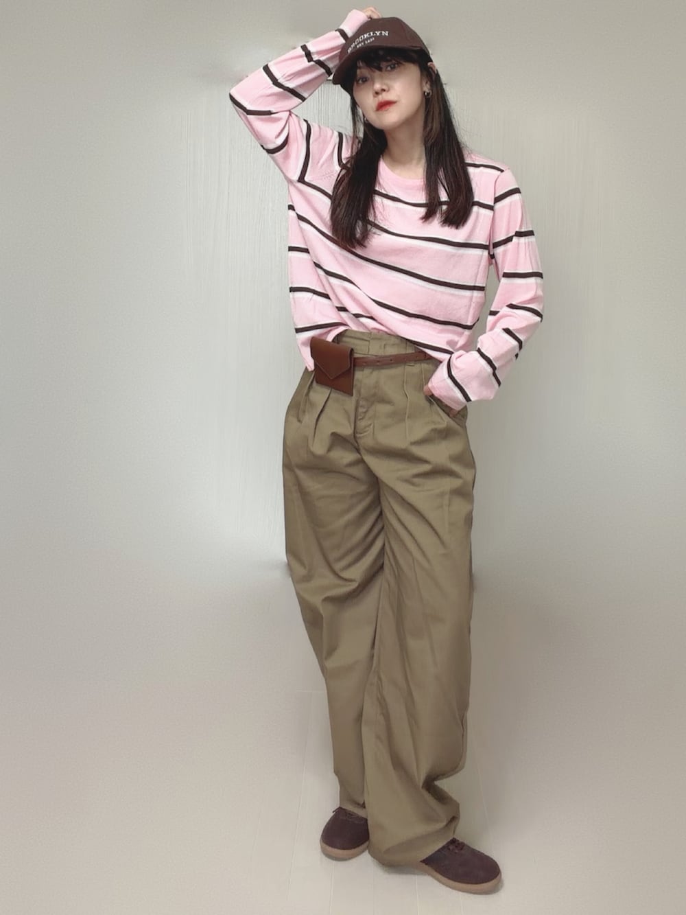 ベージュ系のチノパンツ、ブラウン系のベルトを着用したレディースの秋コーディネートの2枚目の写真
