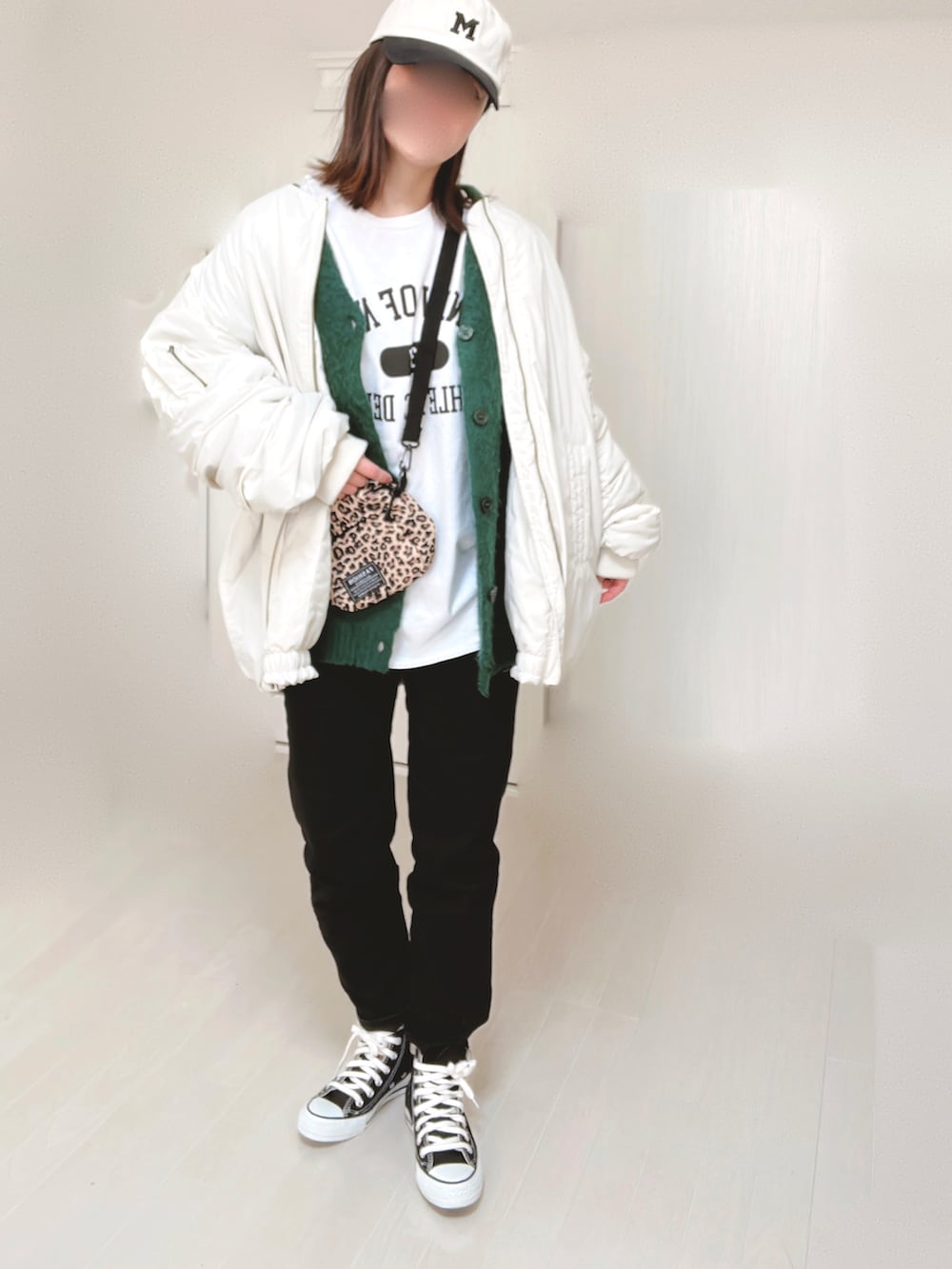 ホワイト系のTシャツ/カットソー、ホワイト系のブルゾン、グリーン系のカーディガン/ボレロを着用したレディースの冬コーディネートの2枚目の写真