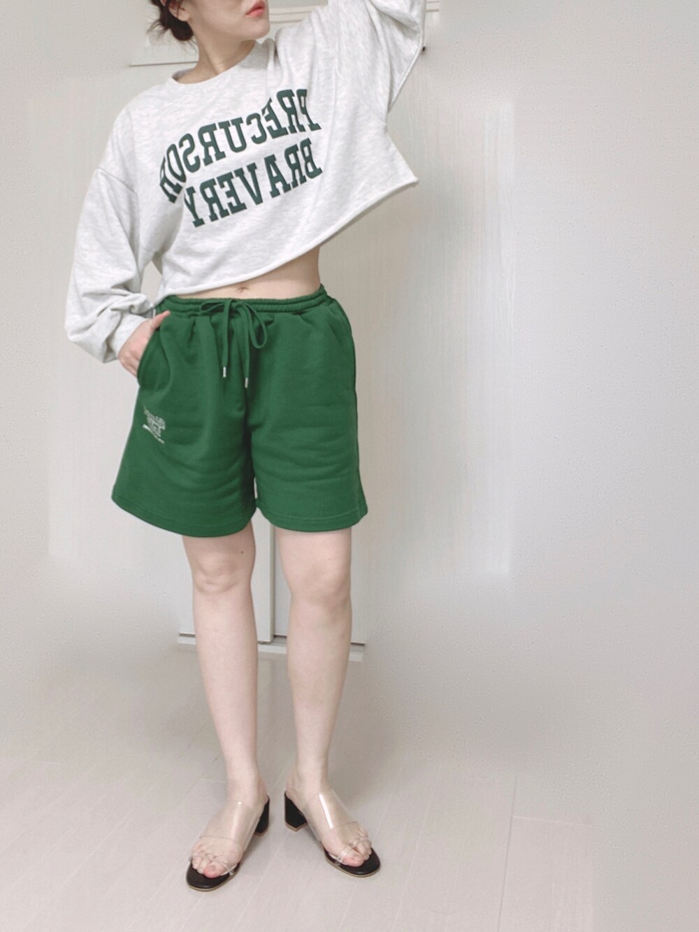 グリーン系のパーカー、グリーン系のその他パンツ、ホワイト系のショルダーバッグを着用したレディースの春コーディネートの4枚目の写真