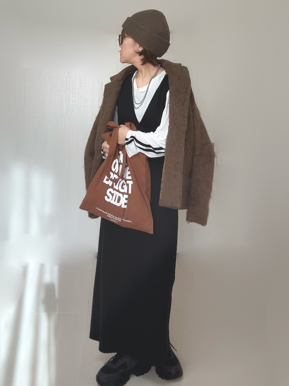 ホワイト系のTシャツ/カットソー、ブラウン系のテーラードジャケット、ブラック系のワンピースを着用したレディースの冬コーディネートの3枚目の写真