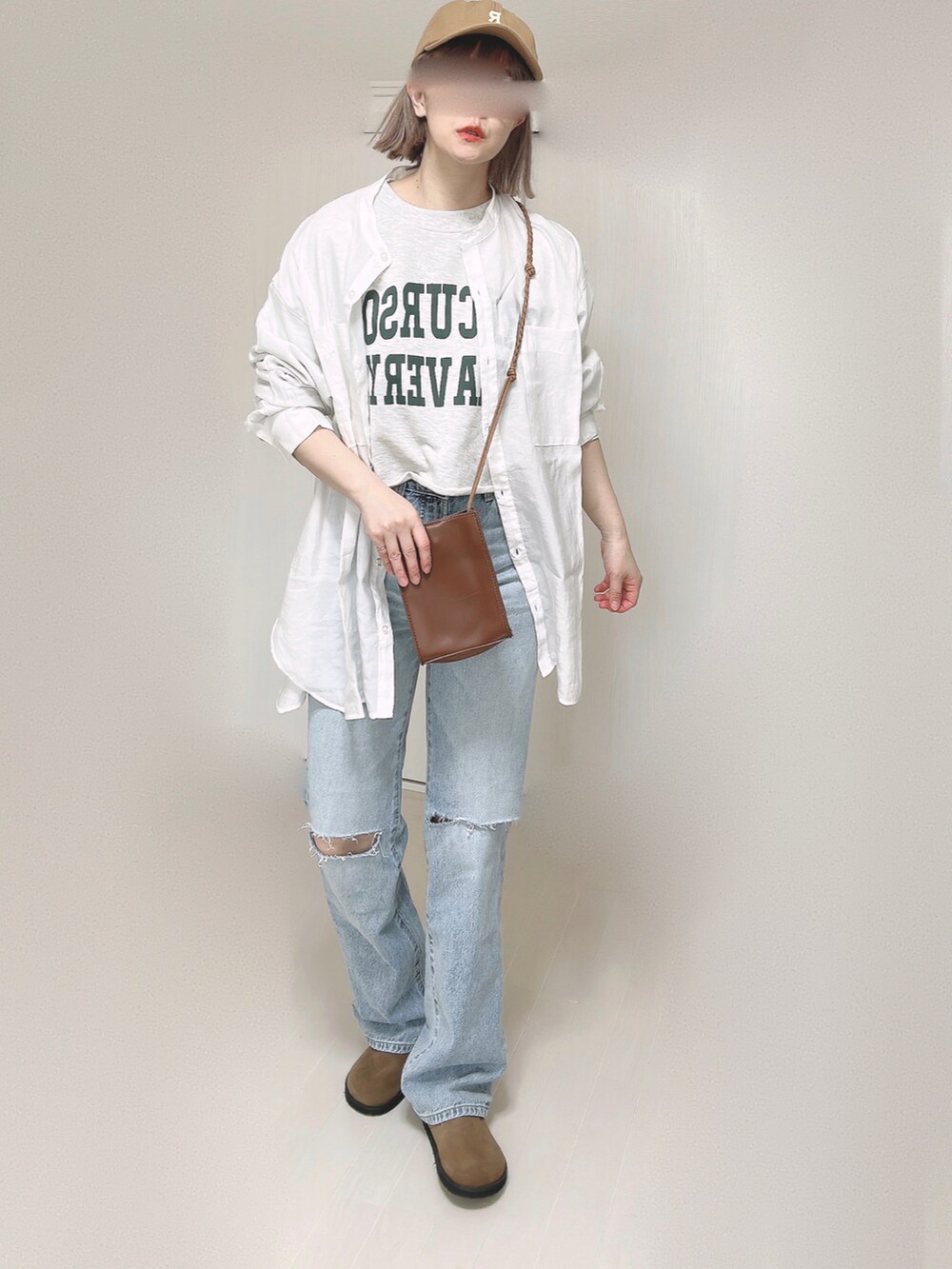 ブルー系のデニムパンツ、ホワイト系のシャツ/ブラウス、ブラウン系のショルダーバッグを着用したレディースの春コーディネートの4枚目の写真