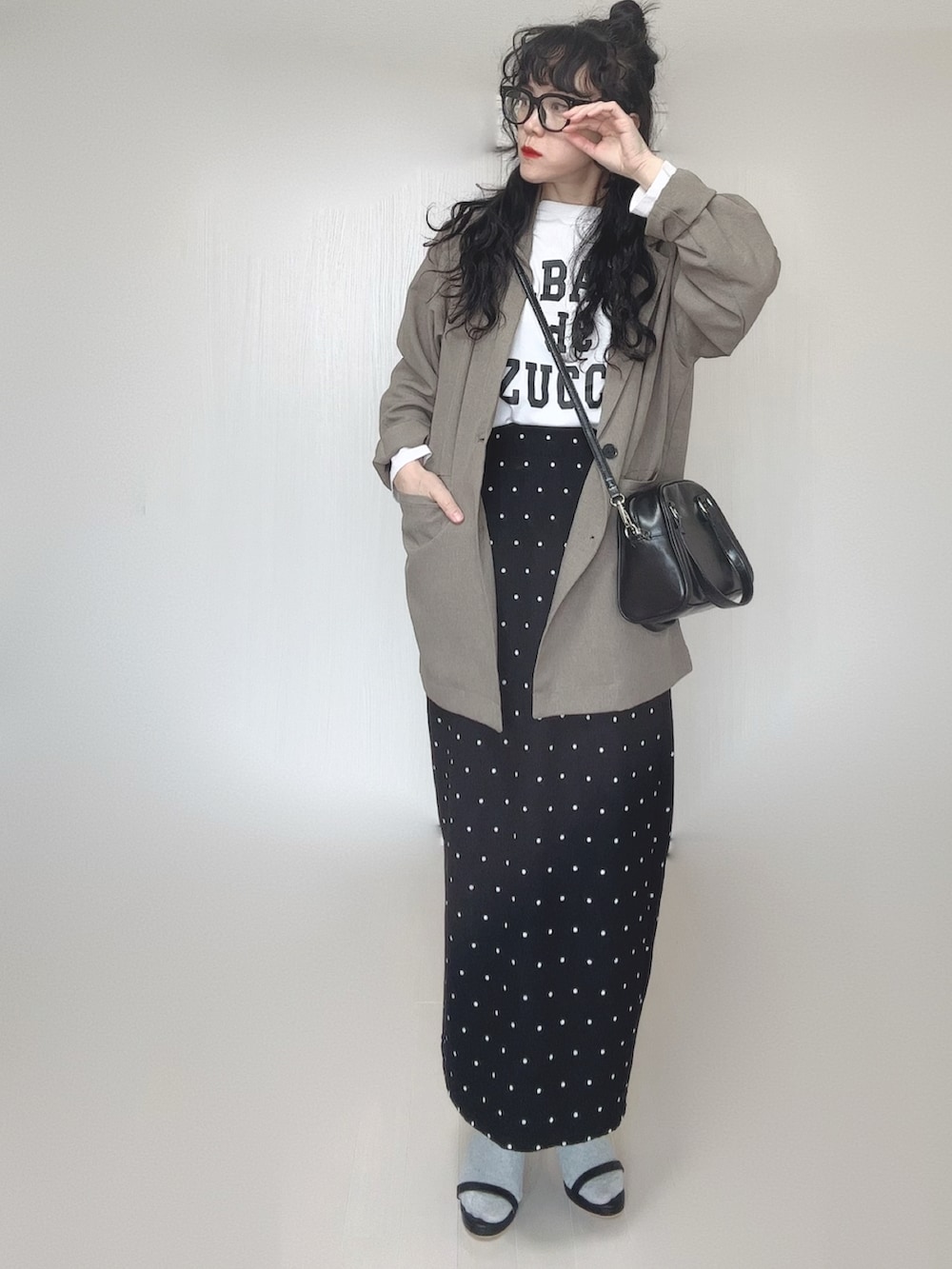 ベージュ系のテーラードジャケット、ブラック系のボストンバッグ、ブラック系のサンダルを着用したレディースの春コーディネートの2枚目の写真