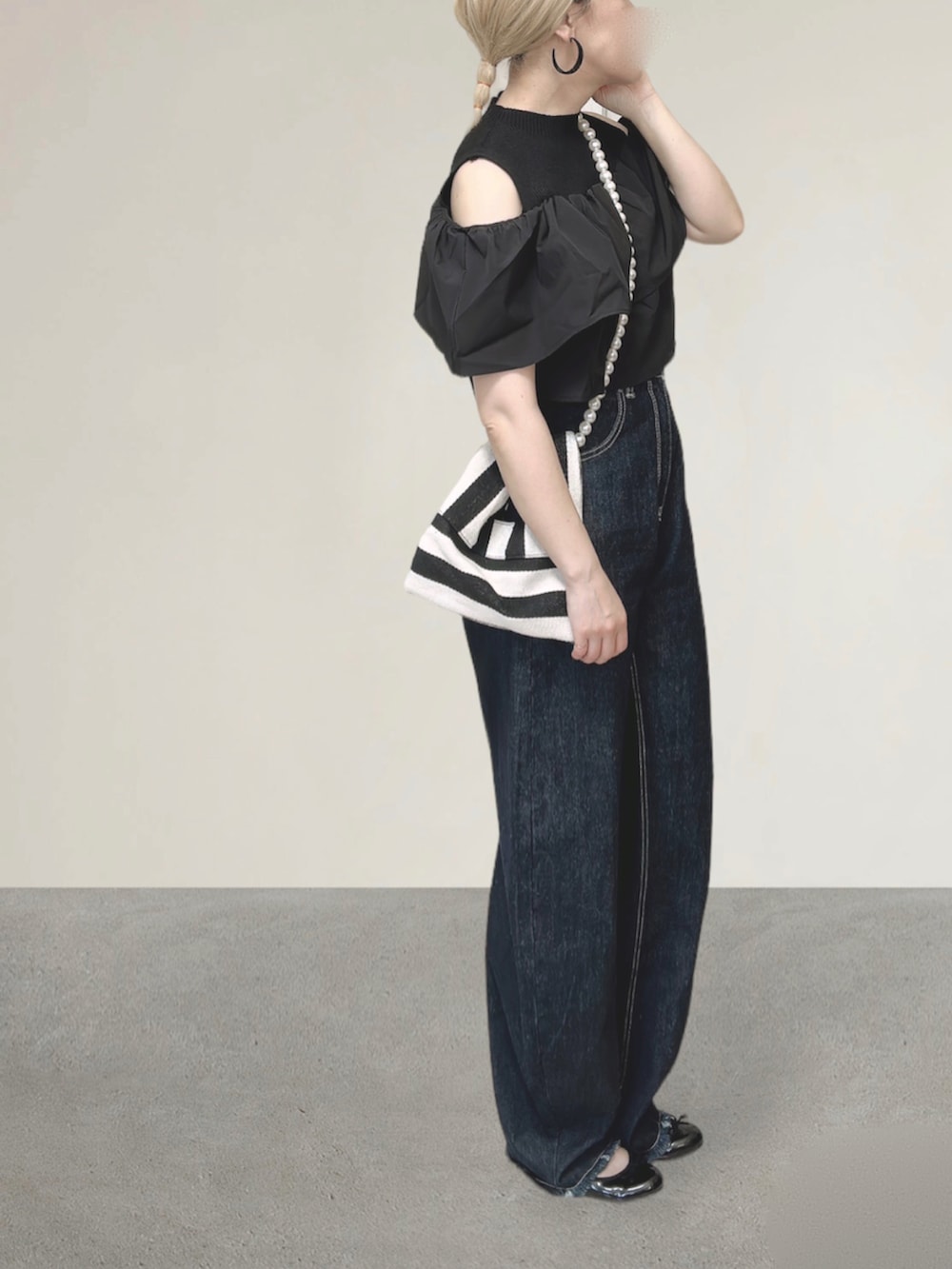 ブルー系のデニムパンツ、ホワイト系のショルダーバッグ、ブラック系のバレエシューズを着用したレディースの秋コーディネートの4枚目の写真