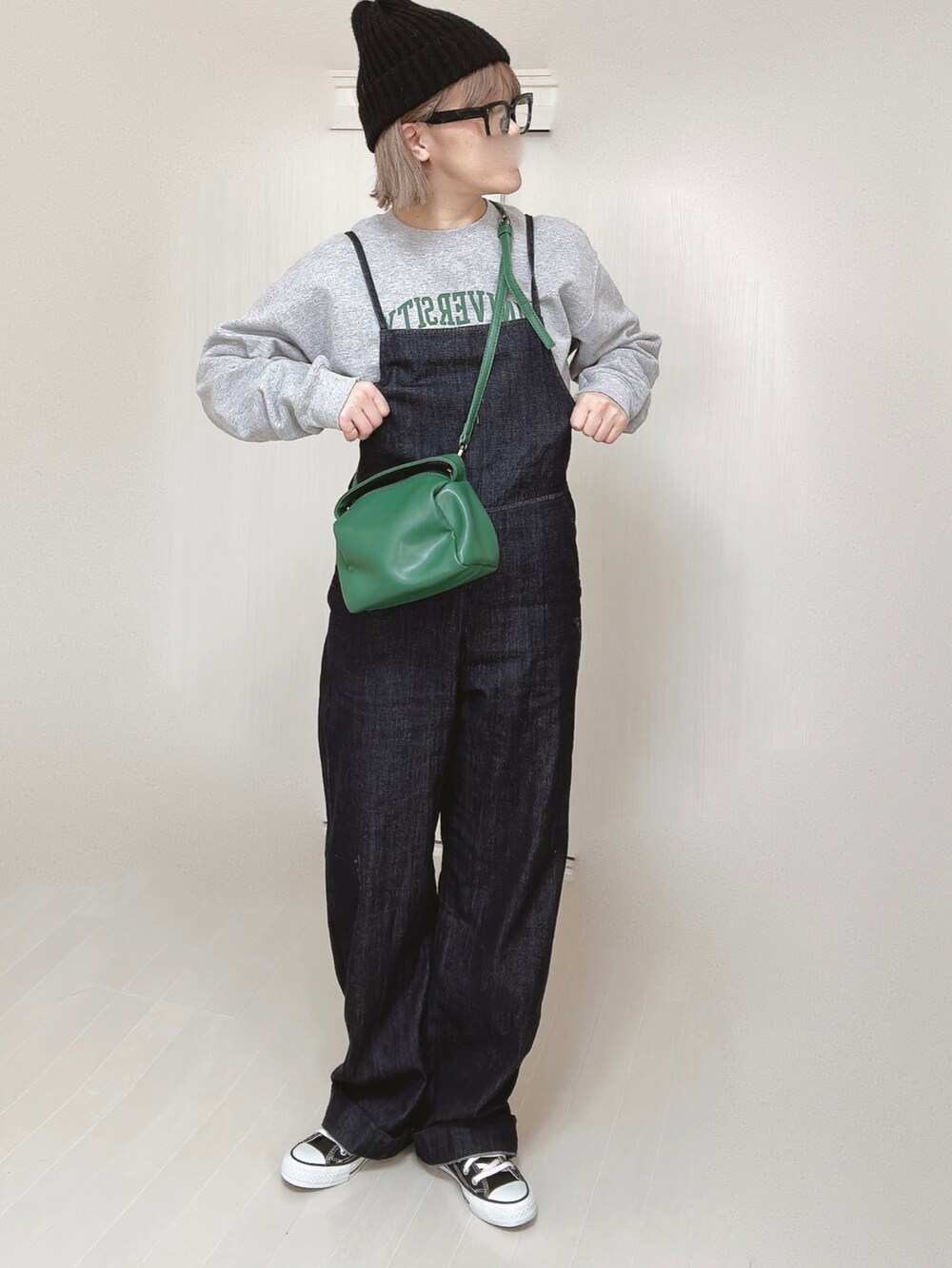 ブルー系のサロペット/オーバーオール、グレー系のスウェット、グリーン系のハンドバッグを着用したレディースの春コーディネートの4枚目の写真