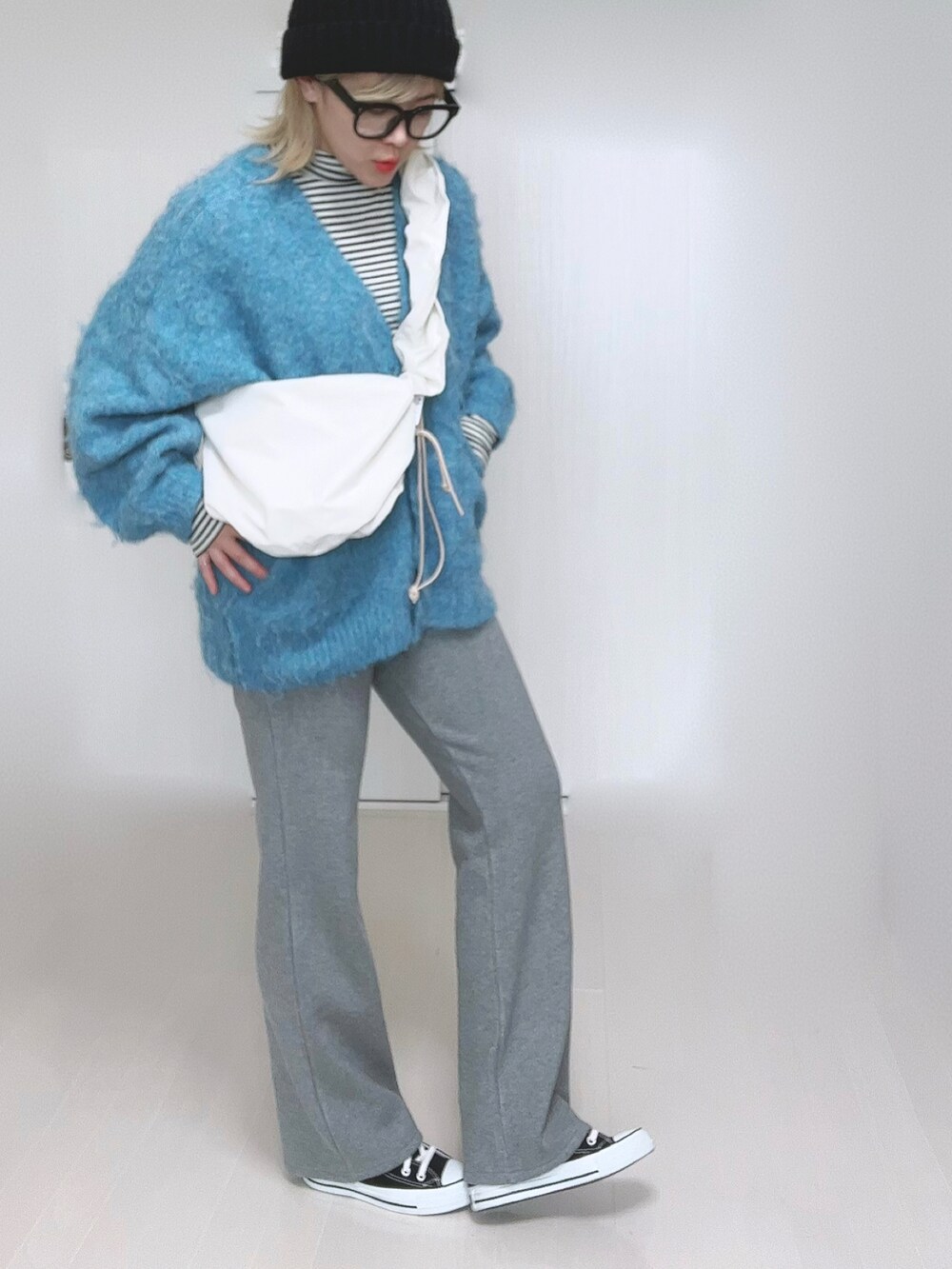 ホワイト系のTシャツ/カットソー、グレー系のその他パンツ、ブラック系のスニーカーを着用したレディースの冬コーディネートの2枚目の写真