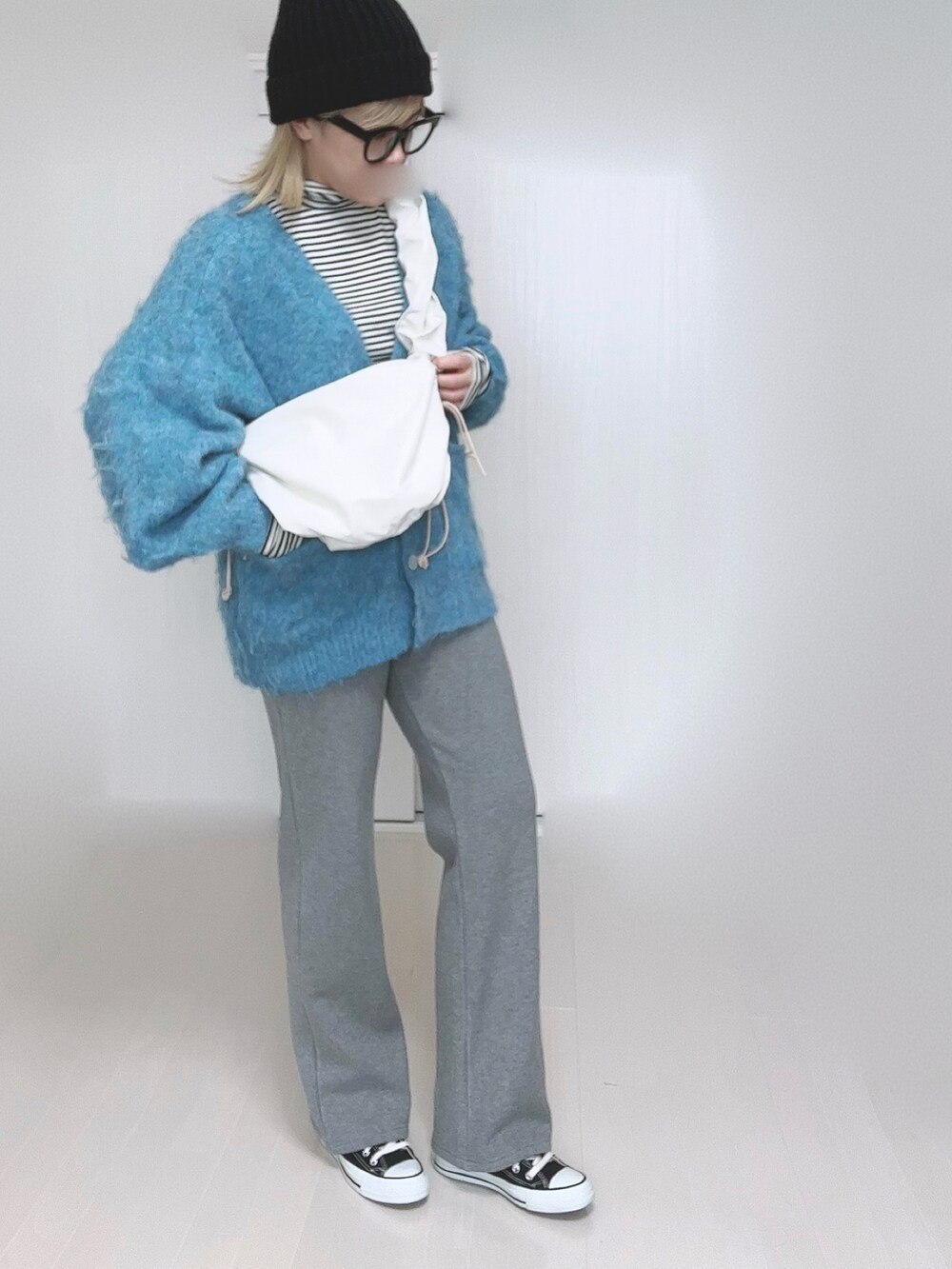 ホワイト系のTシャツ/カットソー、グレー系のその他パンツ、ブラック系のスニーカーを着用したレディースの冬コーディネートの5枚目の写真