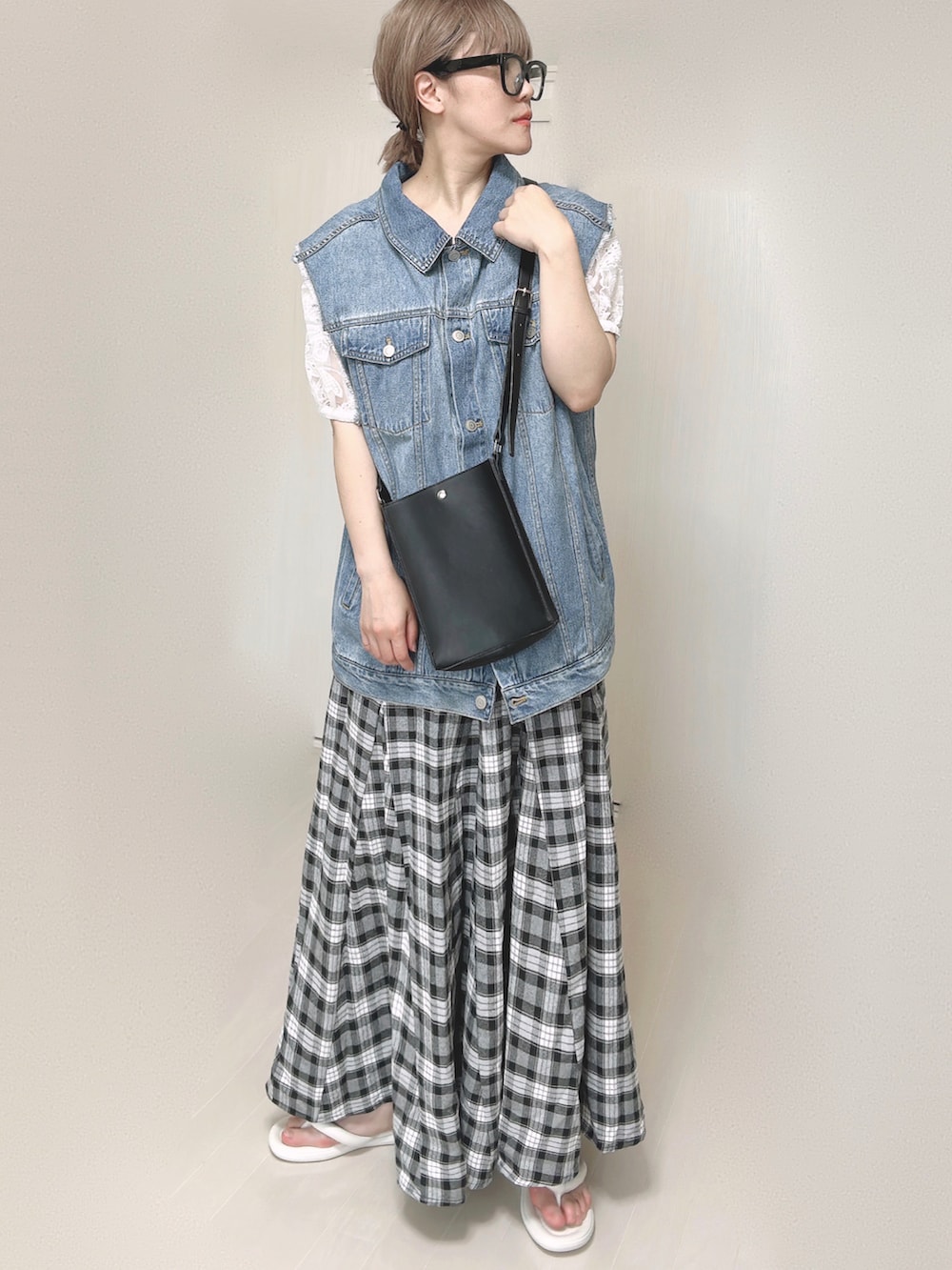 ブルー系のベスト、ホワイト系のシャツ/ブラウス、ブラック系のショルダーバッグを着用したレディースの夏コーディネートの3枚目の写真