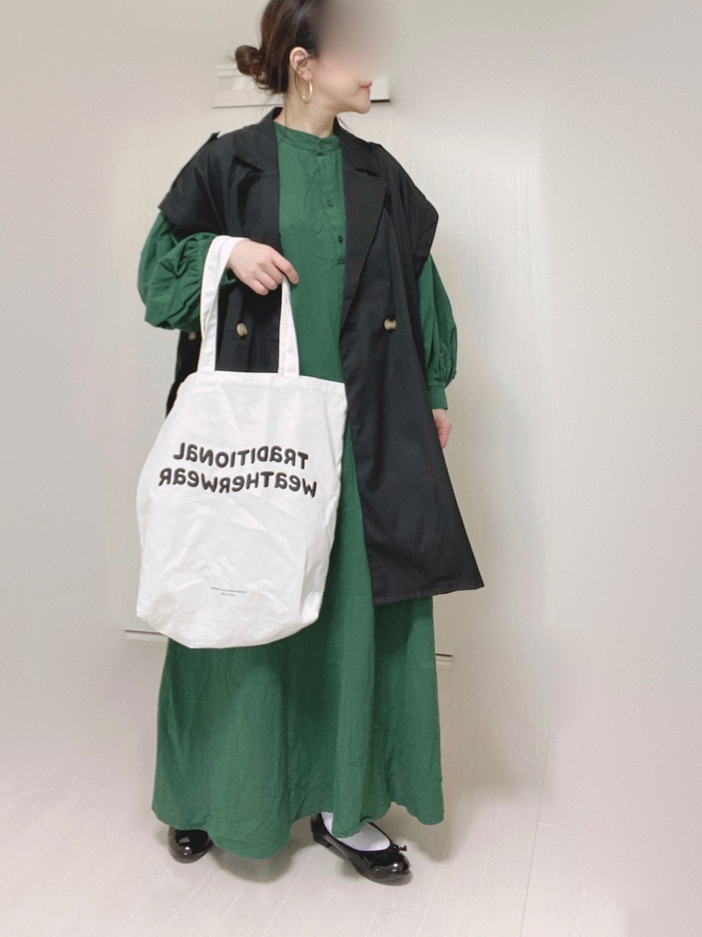 グリーン系のワンピース、ブラック系のその他アウター、ホワイト系のトートバッグを着用したレディースの春コーディネートの2枚目の写真