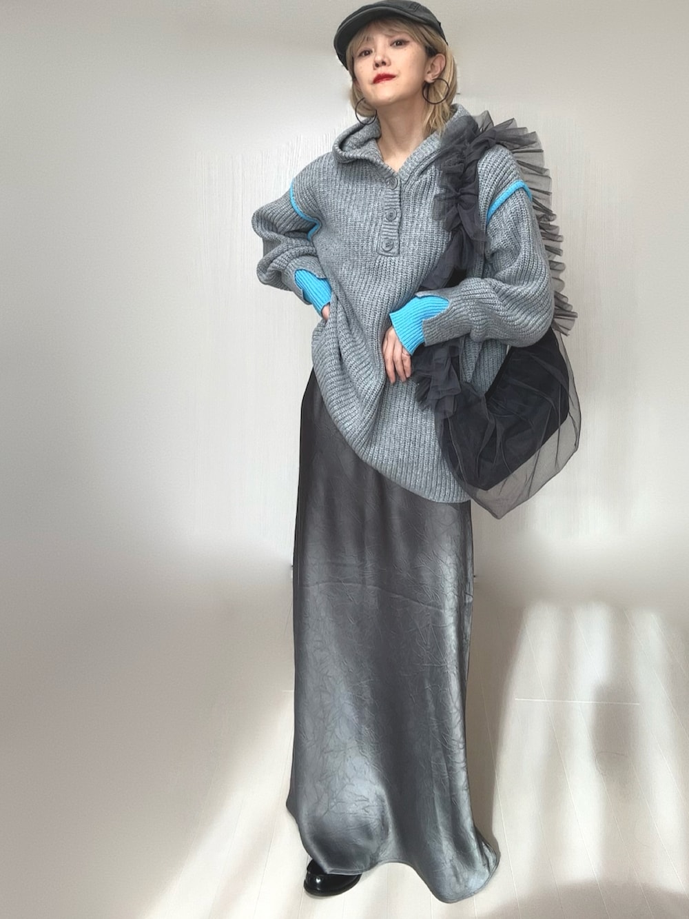 グレー系のニット/セーター、グレー系のスカート、グレー系のショルダーバッグを着用したレディースの冬コーディネートの4枚目の写真