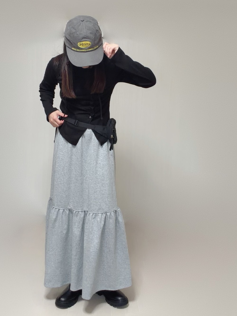 ブラック系のTシャツ/カットソー、グレー系のスカート、ブラック系のボディバッグ/ウエストポーチを着用したレディースの秋コーディネートの2枚目の写真