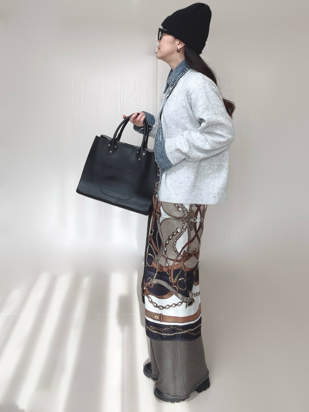 ブラック系のブーツ、ベージュ系のカーディガン/ボレロ、ブラック系のスウェットパンツを着用したレディースの冬コーディネートの3枚目の写真