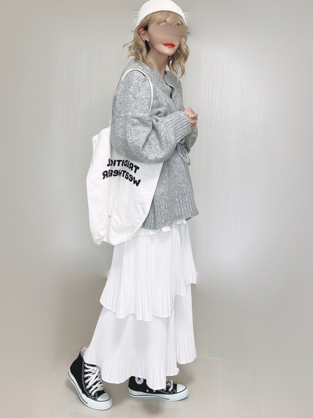 ホワイト系のスカート、ホワイト系のトートバッグ、ブラック系のスニーカーを着用したレディースの秋コーディネートの4枚目の写真