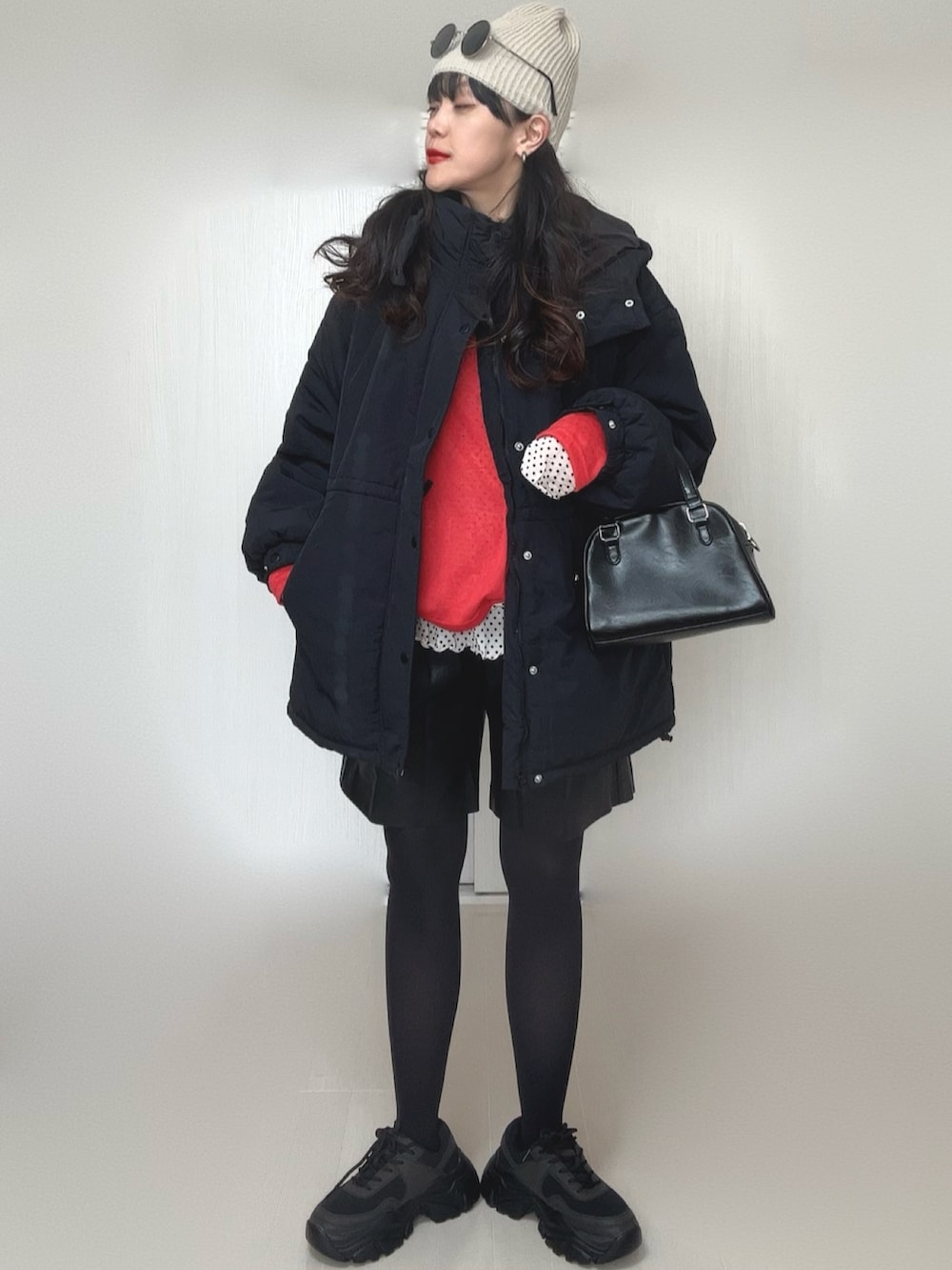 ホワイト系のTシャツ/カットソー、ブラック系のダウンジャケット/コート、レッド系のTシャツ/カットソーを着用したレディースの冬コーディネートの2枚目の写真