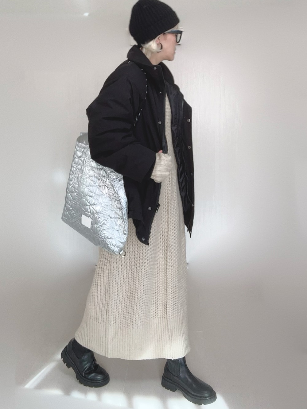 ブラック系のブルゾン、ホワイト系のワンピース、シルバー系のトートバッグを着用したレディースの冬コーディネートの5枚目の写真