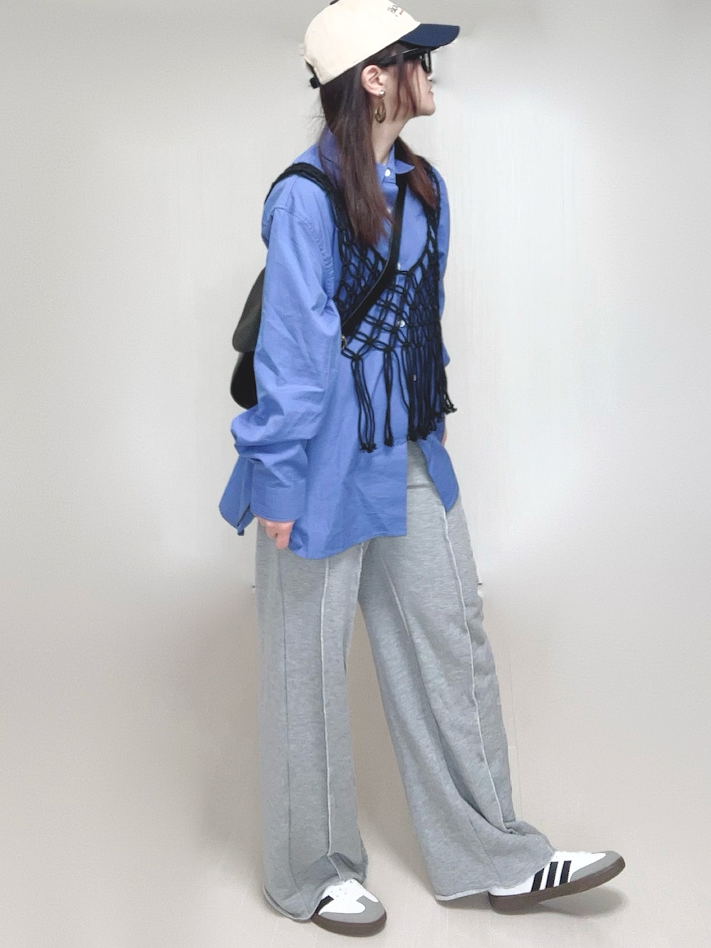 ブラック系のベスト、ブルー系のシャツ/ブラウス、グレー系のスウェットパンツを着用したレディースの春コーディネートの5枚目の写真