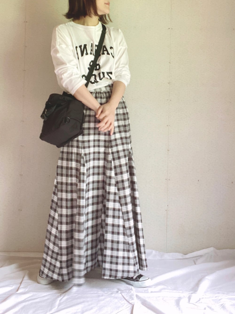 ホワイト系のTシャツ/カットソー、ブラック系のショルダーバッグ、ブラック系のスカートを着用したレディースの夏コーディネートの4枚目の写真