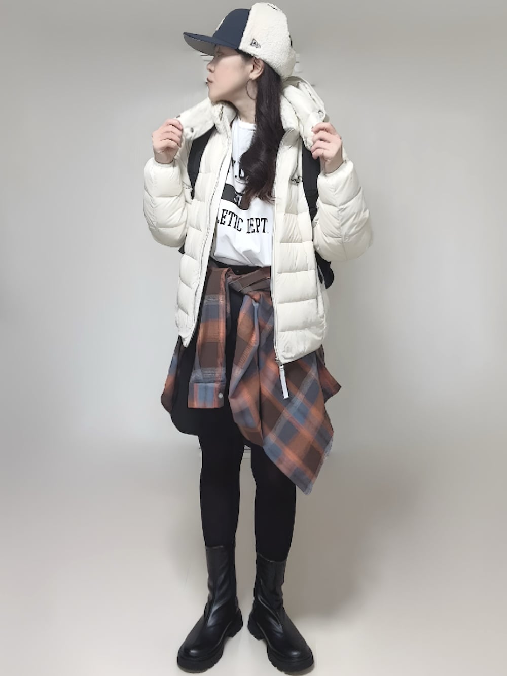 ホワイト系のTシャツ/カットソー、ホワイト系のダウンジャケット/コート、ブラック系のブーツを着用したレディースの冬コーディネートの3枚目の写真