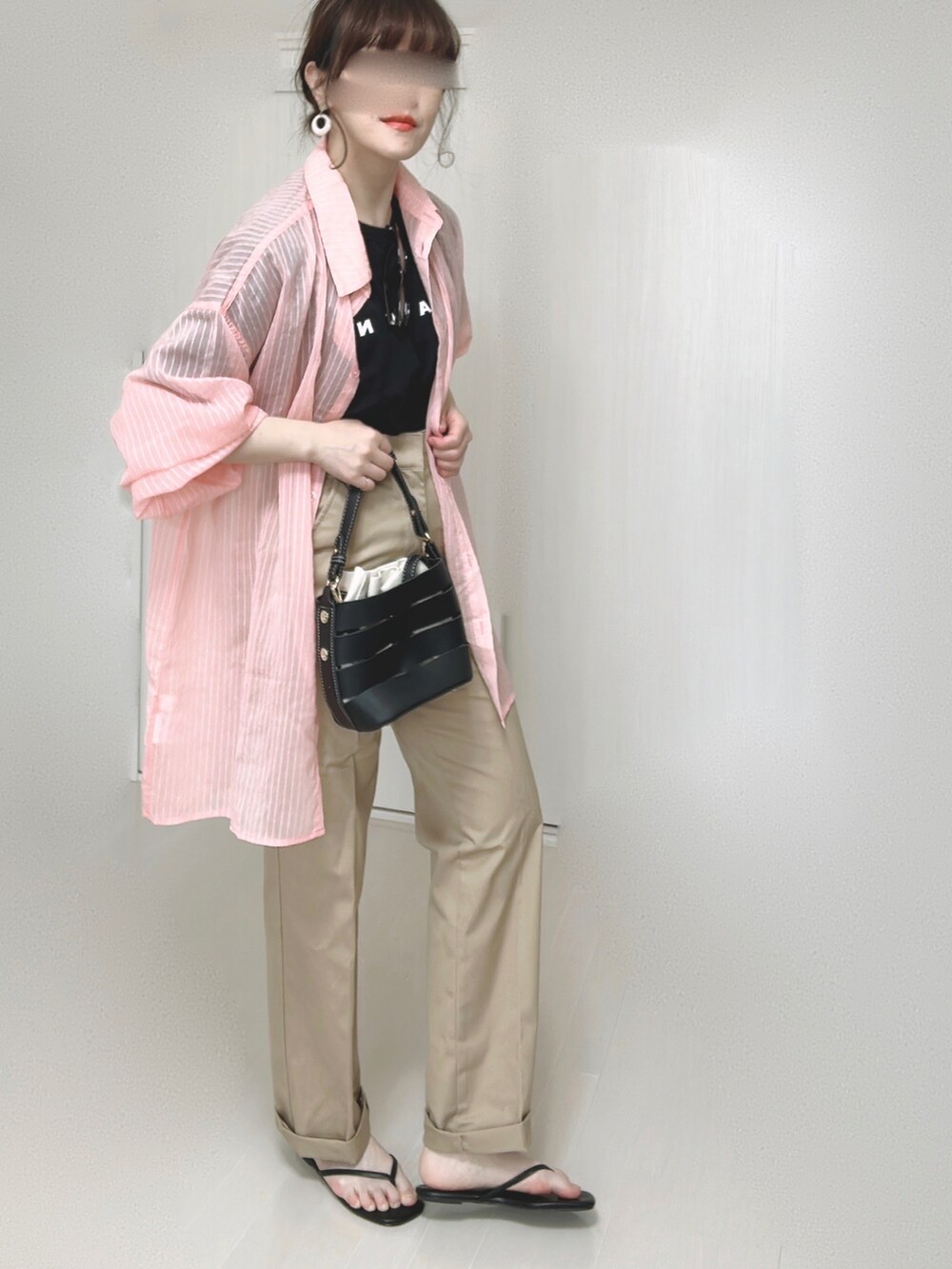 ブラック系のTシャツ/カットソー、ピンク系のシャツ/ブラウス、ベージュ系のチノパンツを着用したレディースの春コーディネートの3枚目の写真