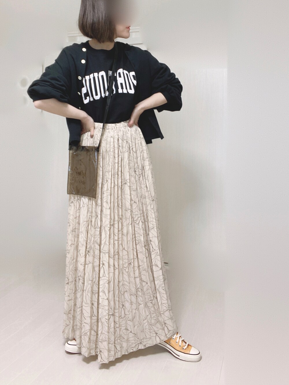 ブラック系のカーディガン/ボレロ、ホワイト系のスカート、ブラック系のTシャツ/カットソーを着用したレディースの春コーディネートの2枚目の写真