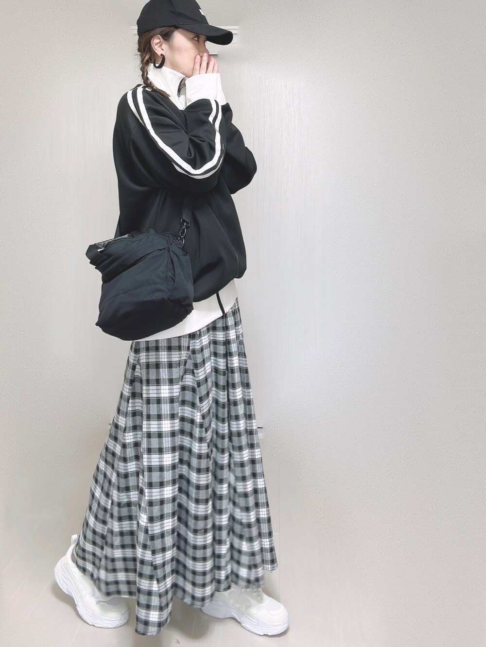 ブラック系のブルゾン、ブラック系のショルダーバッグ、ブラック系のスカートを着用したレディースの秋コーディネートの5枚目の写真