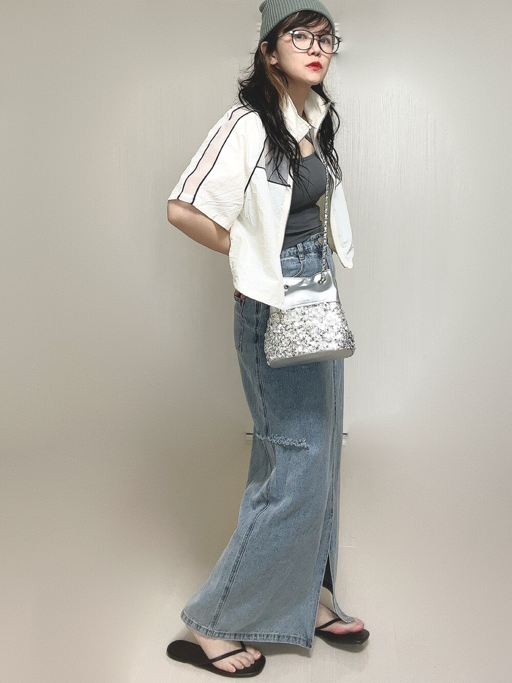 ホワイト系のブルゾン、グレー系のキャミソール、シルバー系のショルダーバッグを着用したレディースの夏コーディネートの4枚目の写真