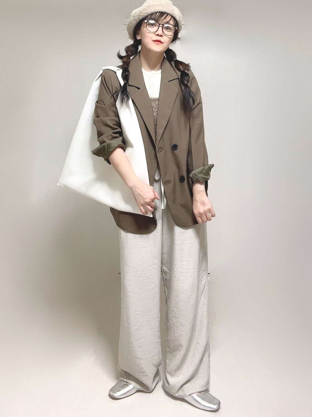 ホワイト系のTシャツ/カットソー、ブラウン系のテーラードジャケット、ホワイト系のショルダーバッグを着用したレディースの秋コーディネートの4枚目の写真