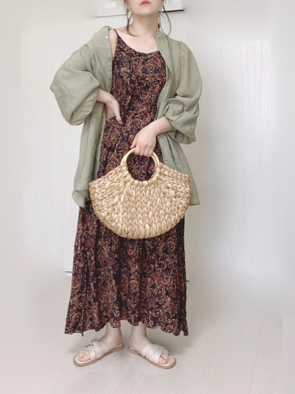 ブラック系のワンピース、グリーン系のシャツ/ブラウス、ホワイト系のサンダルを着用したレディースの春コーディネートの4枚目の写真