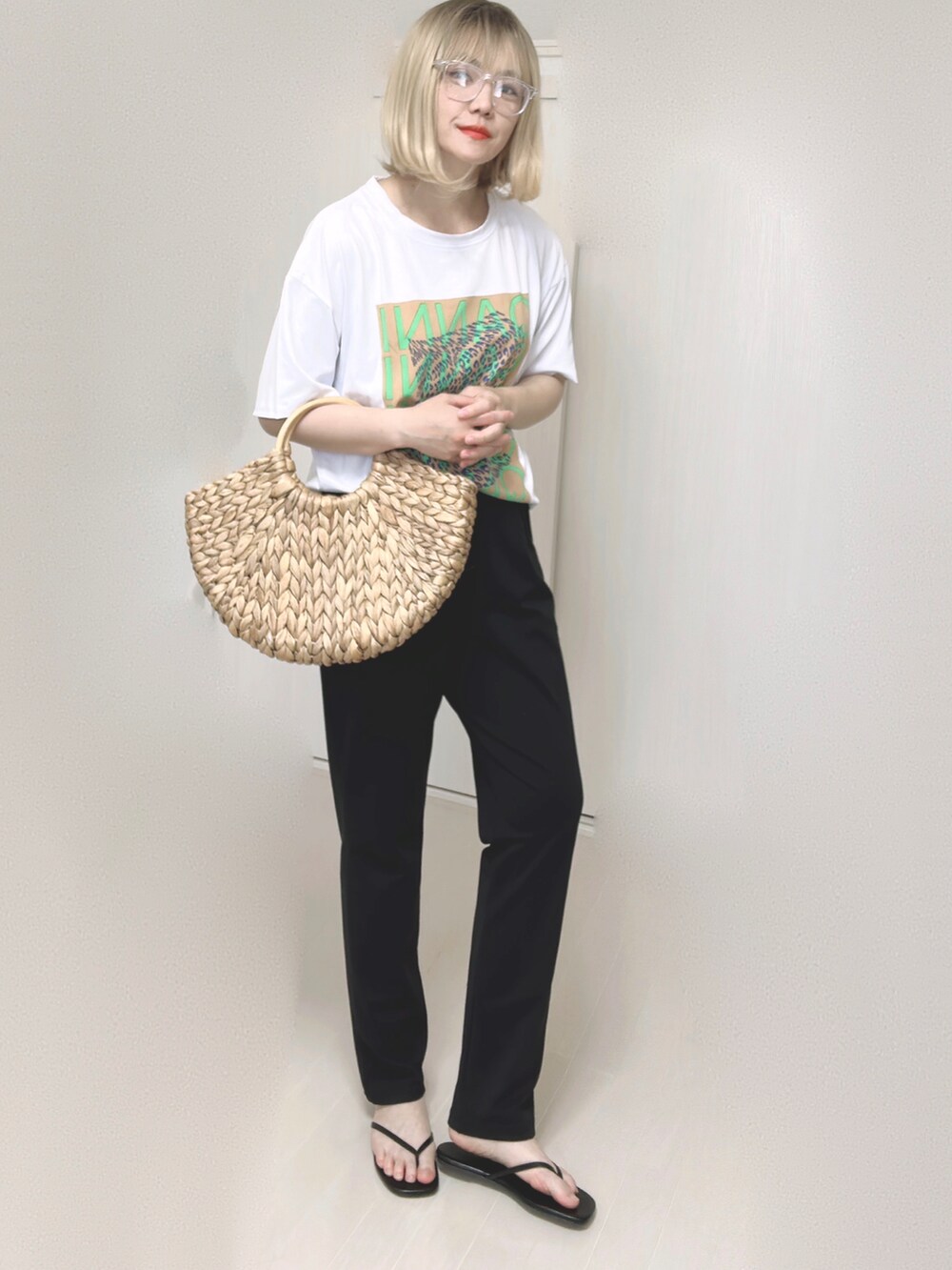 ベージュ系のかごバッグ、ブラック系のサンダルを着用したレディースの夏コーディネートの2枚目の写真