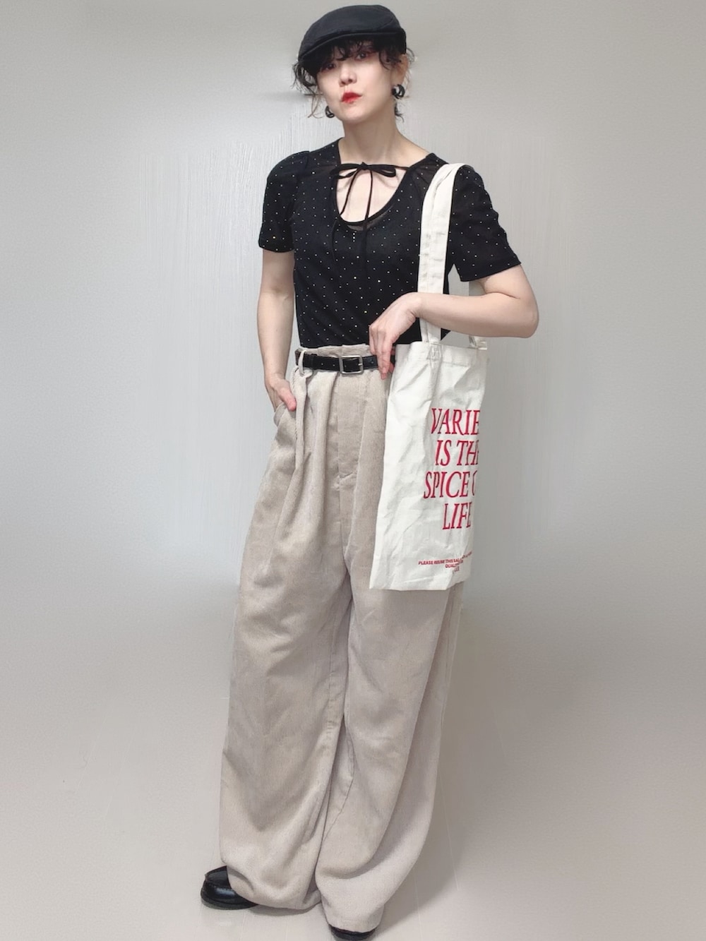 ブラック系のTシャツ/カットソー、ホワイト系のトートバッグ、ベージュ系のスラックスを着用したレディースの夏コーディネートの5枚目の写真