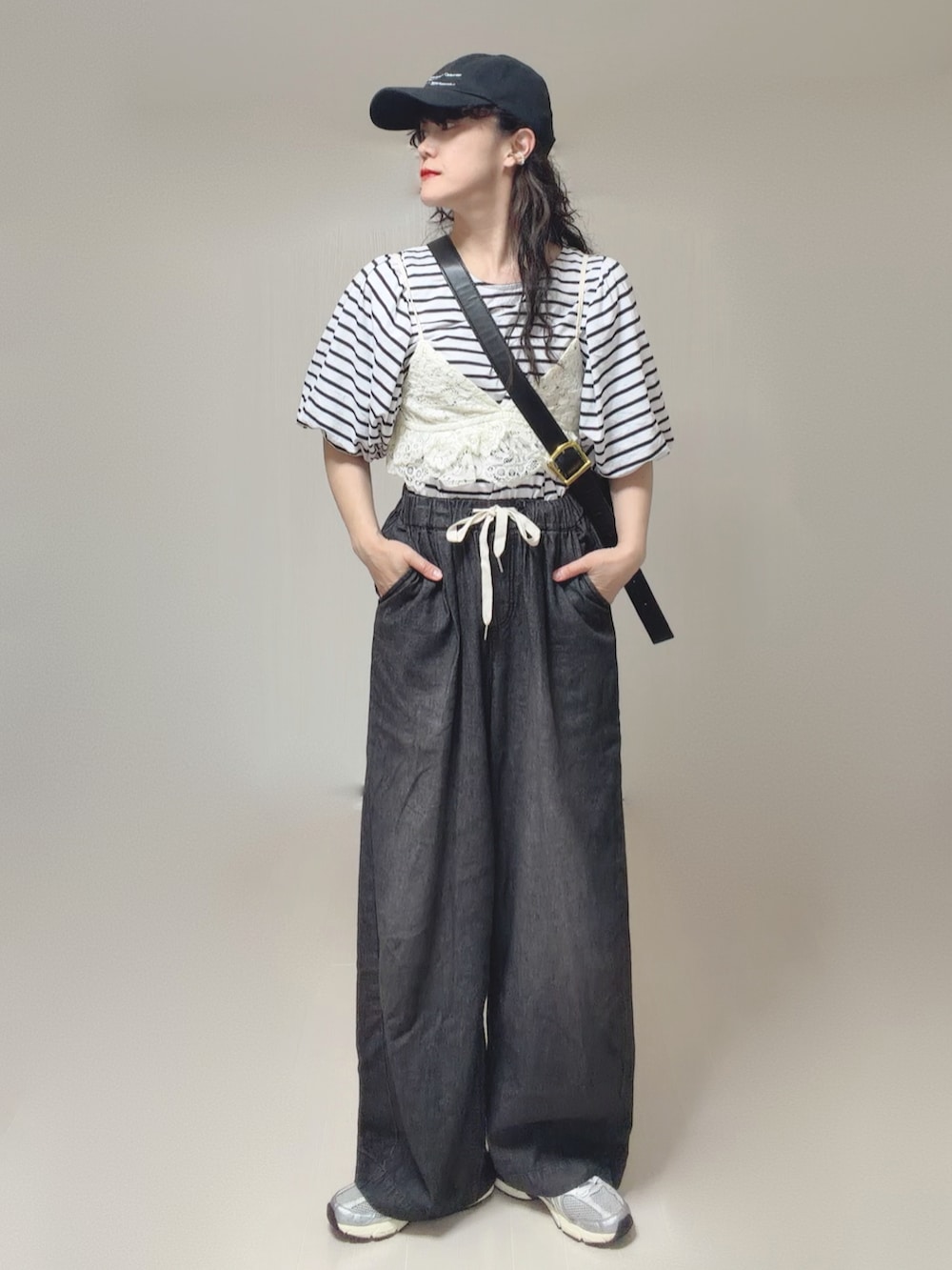 ホワイト系のキャミソール、ブラック系のTシャツ/カットソー、ブラック系のデニムパンツを着用したレディースの夏コーディネートの5枚目の写真