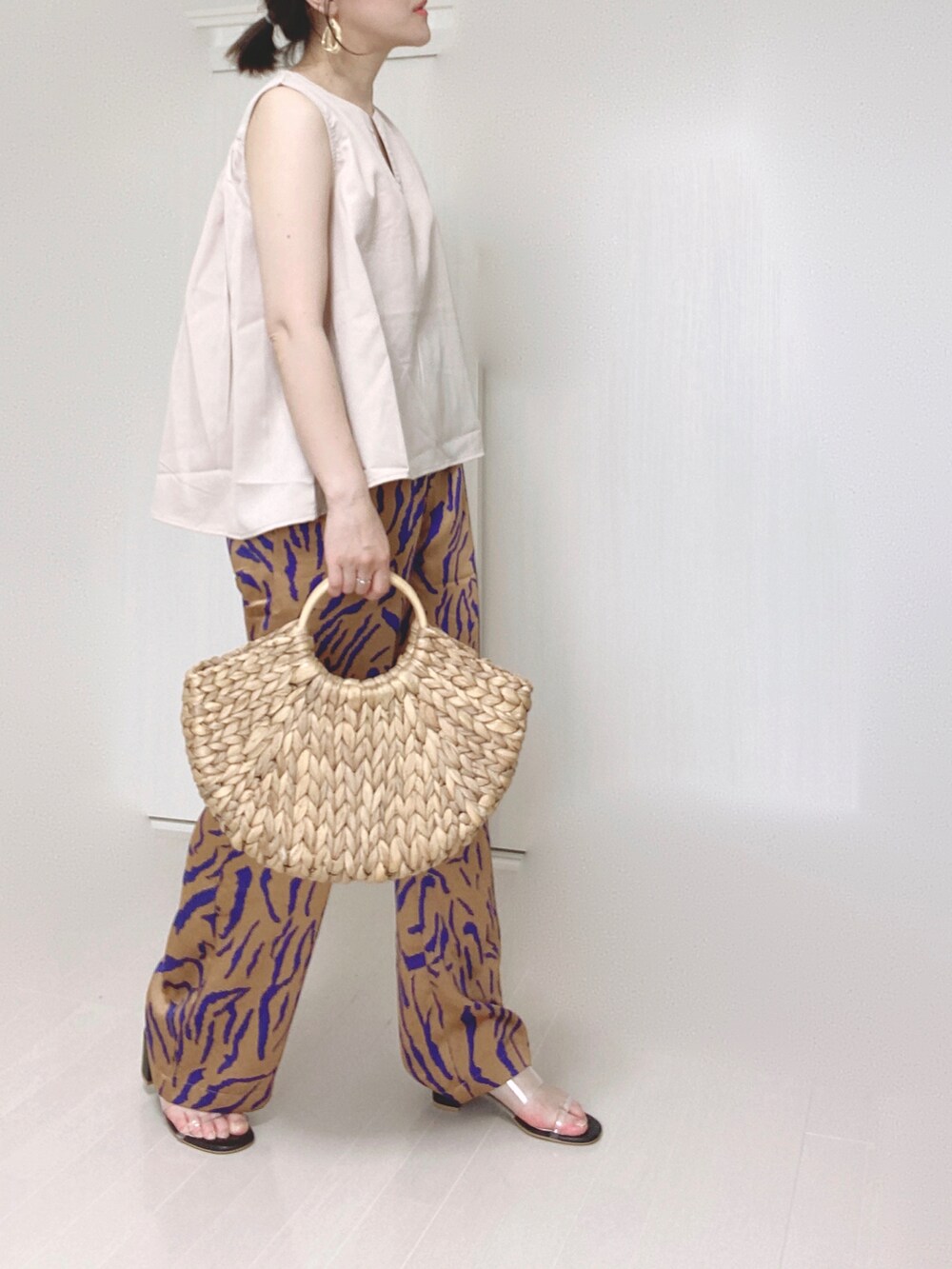 ホワイト系のシャツ/ブラウス、オレンジ系のその他パンツ、ベージュ系のかごバッグを着用したレディースの夏コーディネートの3枚目の写真