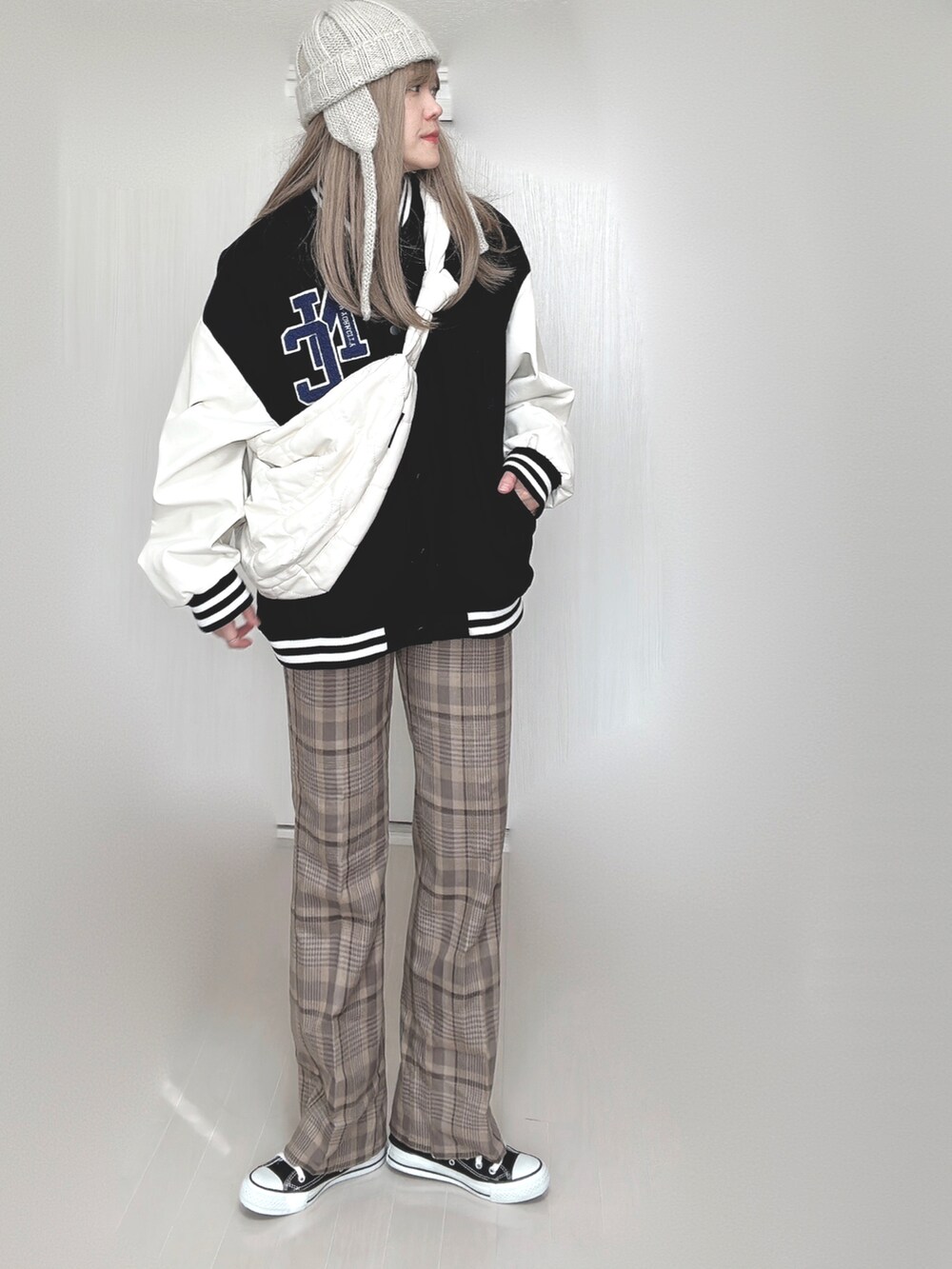 ブラック系のスタジャン、ホワイト系のショルダーバッグ、ベージュ系のその他パンツを着用したレディースの秋コーディネートの3枚目の写真