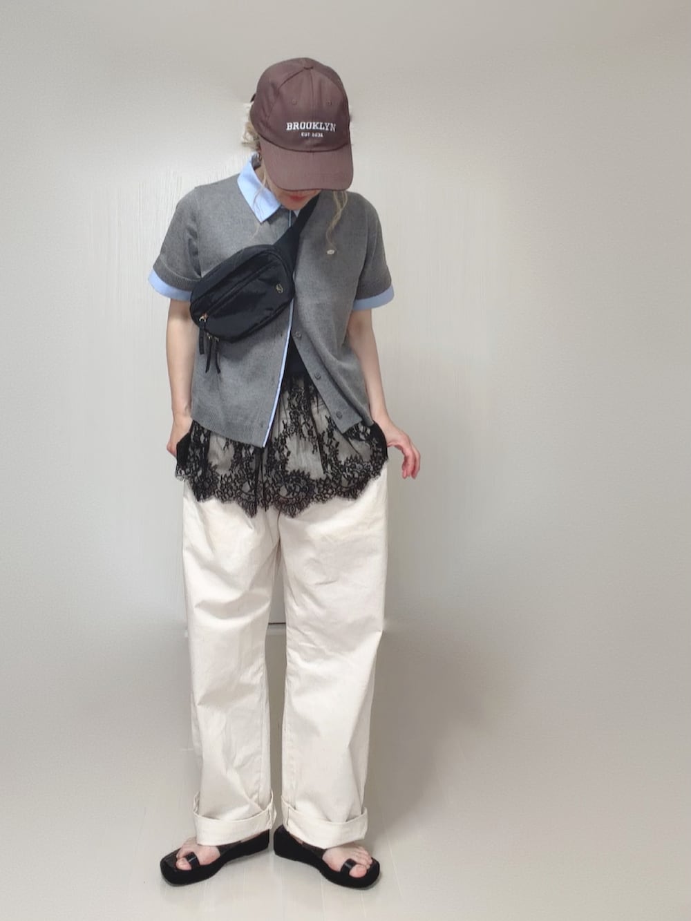 ブラック系のキャミソール、グレー系のカーディガン/ボレロ、ブラック系のボディバッグ/ウエストポーチを着用したレディースの夏コーディネートの2枚目の写真