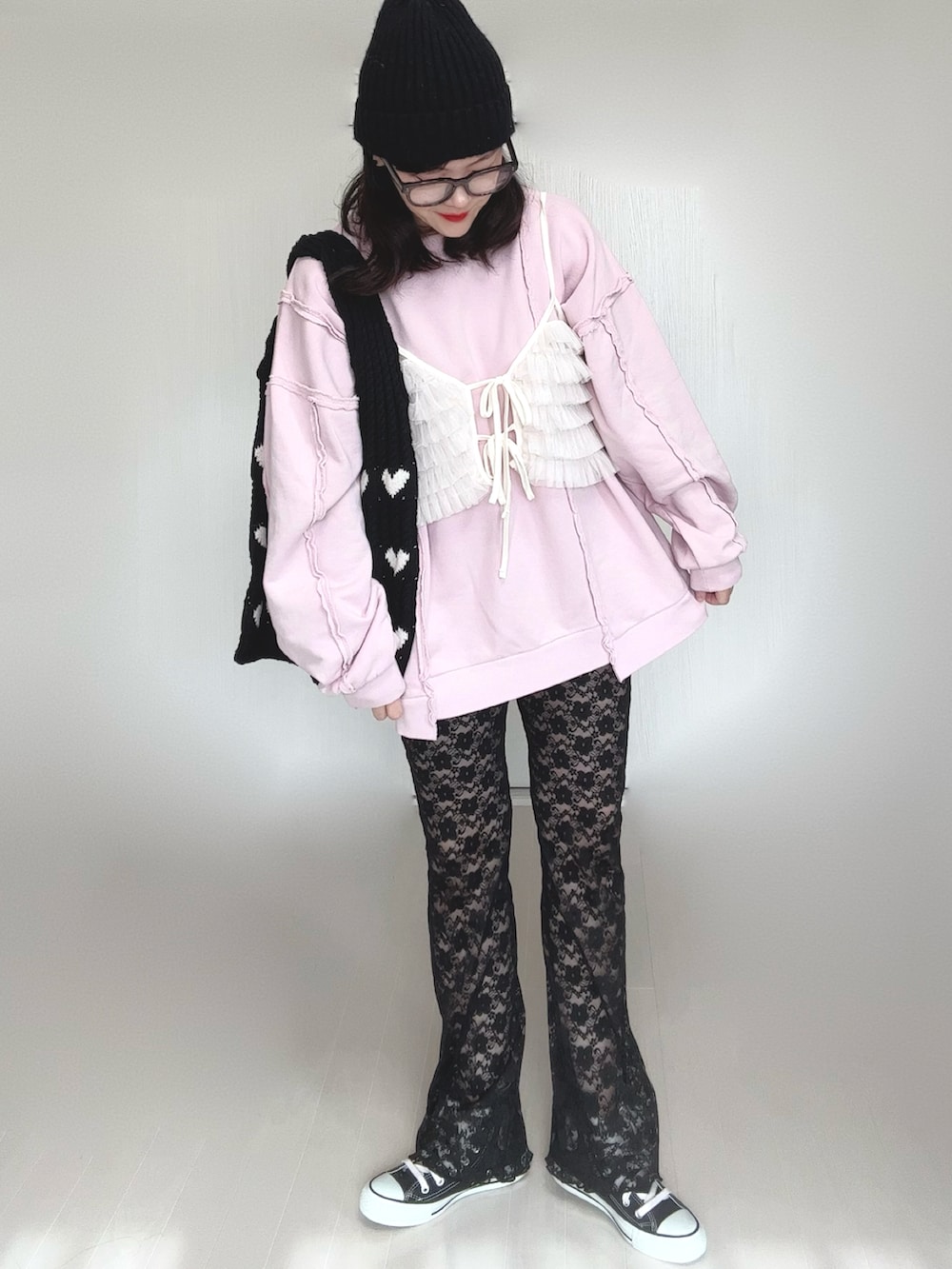 ピンク系のスウェット、ブラック系のその他パンツ、ブラック系のスニーカーを着用したレディースの冬コーディネートの2枚目の写真