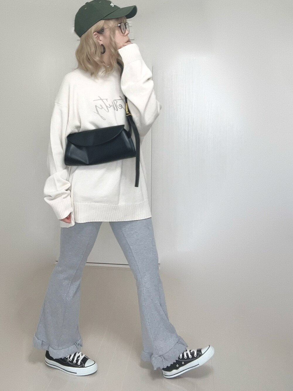 ホワイト系のニット/セーター、グレー系のその他パンツ、ブラック系のスニーカーを着用したレディースの秋コーディネートの3枚目の写真